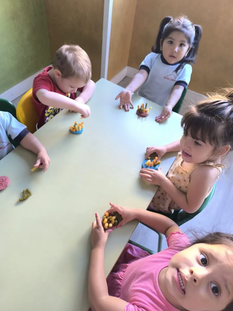 Niños y niñas jugando alrededor de una mesa